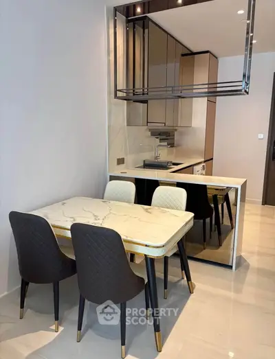 Modern kitchen with elegant dining area and sleek marble table in a stylish apartment.