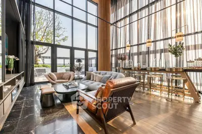 Luxurious living room with high ceilings and large windows offering stunning views.