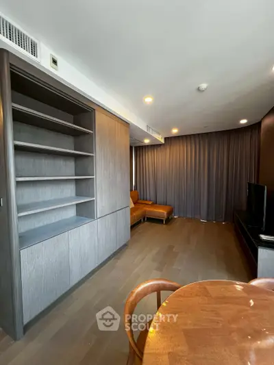 Spacious modern living room with built-in shelves and elegant wooden flooring.