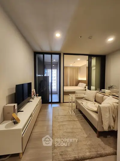 Modern living room with cozy decor and view into stylish bedroom