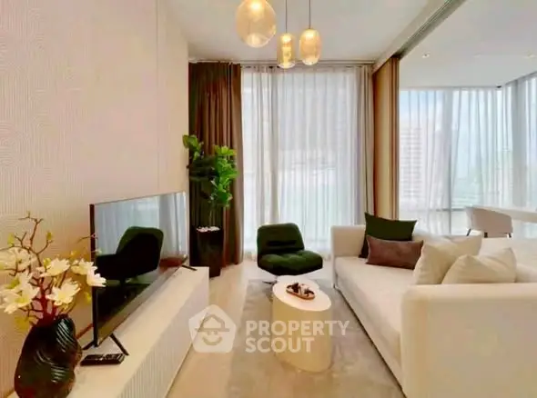 Modern living room with elegant decor and large windows offering natural light.