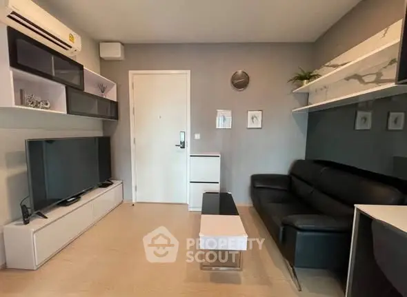 Modern living room with sleek black sofa and wall-mounted TV unit