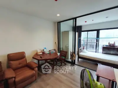 Modern studio apartment with cozy living area and bedroom, featuring large windows and stylish furniture.
