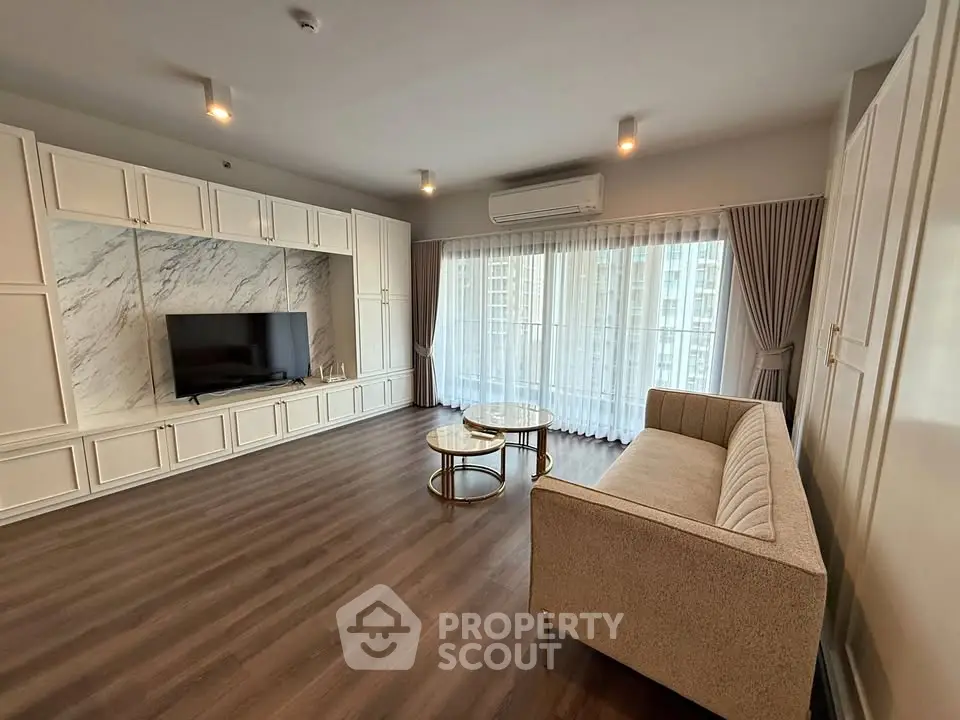 Spacious living room with elegant decor and large windows offering natural light.