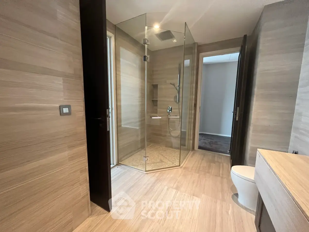 Luxurious modern bathroom with glass shower and sleek wooden finishes