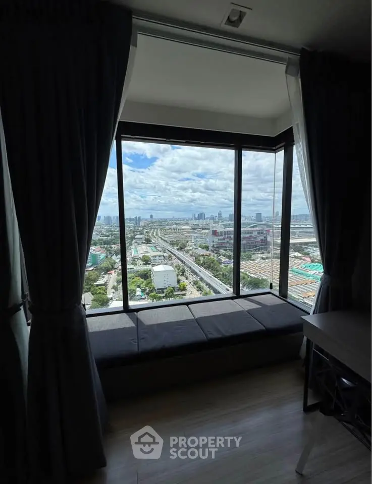 Stunning high-rise apartment with panoramic city view from large window seat.