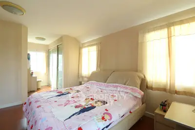 Cozy bedroom with cartoon-themed bedding and ample natural light
