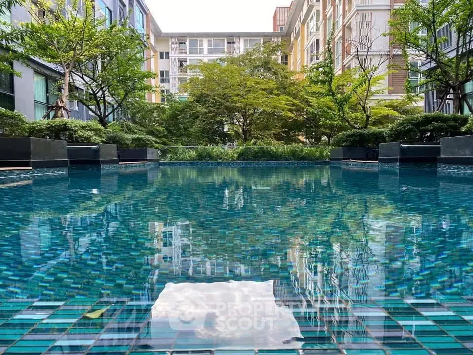 Luxurious residential pool surrounded by lush greenery and modern architecture.