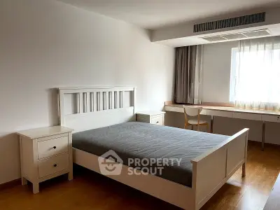 Spacious bedroom with modern furniture and natural light