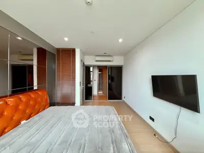 Spacious modern bedroom with sleek design and wall-mounted TV
