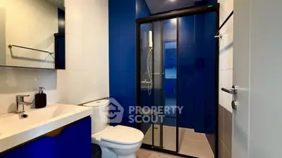 Modern bathroom with sleek blue accents and glass shower enclosure
