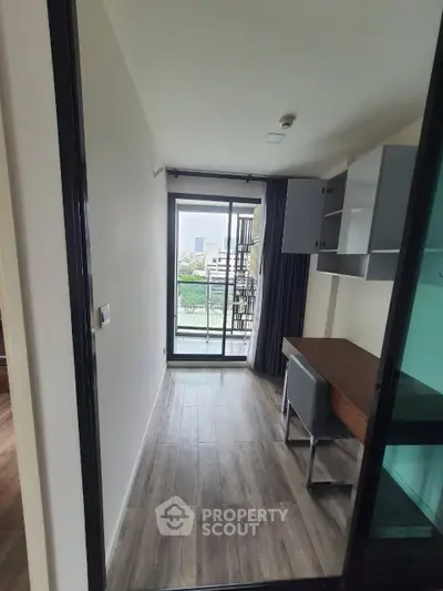 Modern study room with desk and chair, featuring a large window with city view.