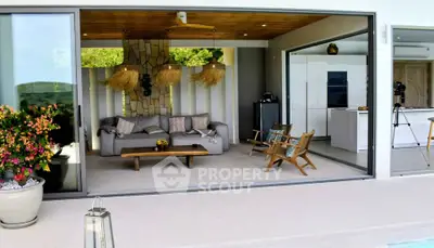 Luxurious open-plan living room with poolside view and modern decor