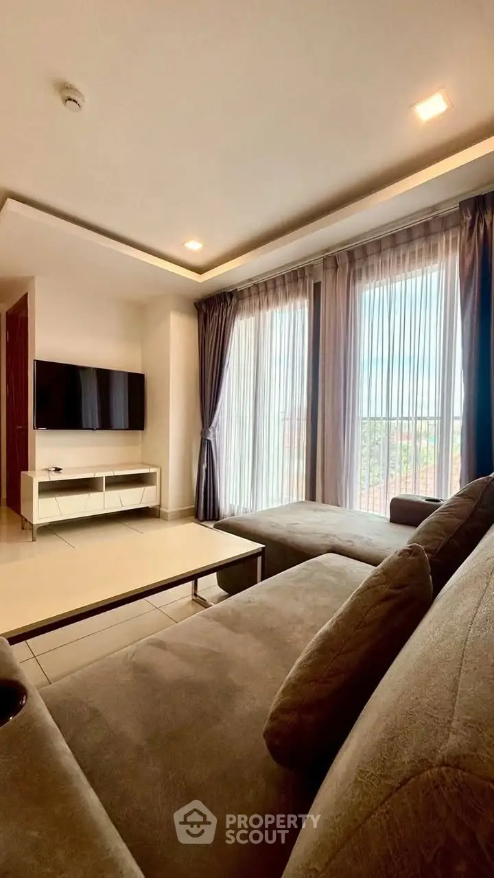 Spacious living room with modern decor and large windows offering natural light and scenic views.