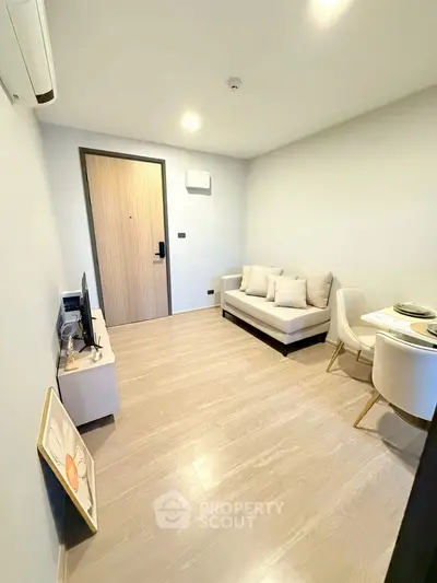 Modern living room with cozy sofa and dining area in a compact apartment.