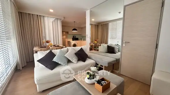 Modern living room with open kitchen, stylish decor, and cozy seating area in a contemporary apartment.