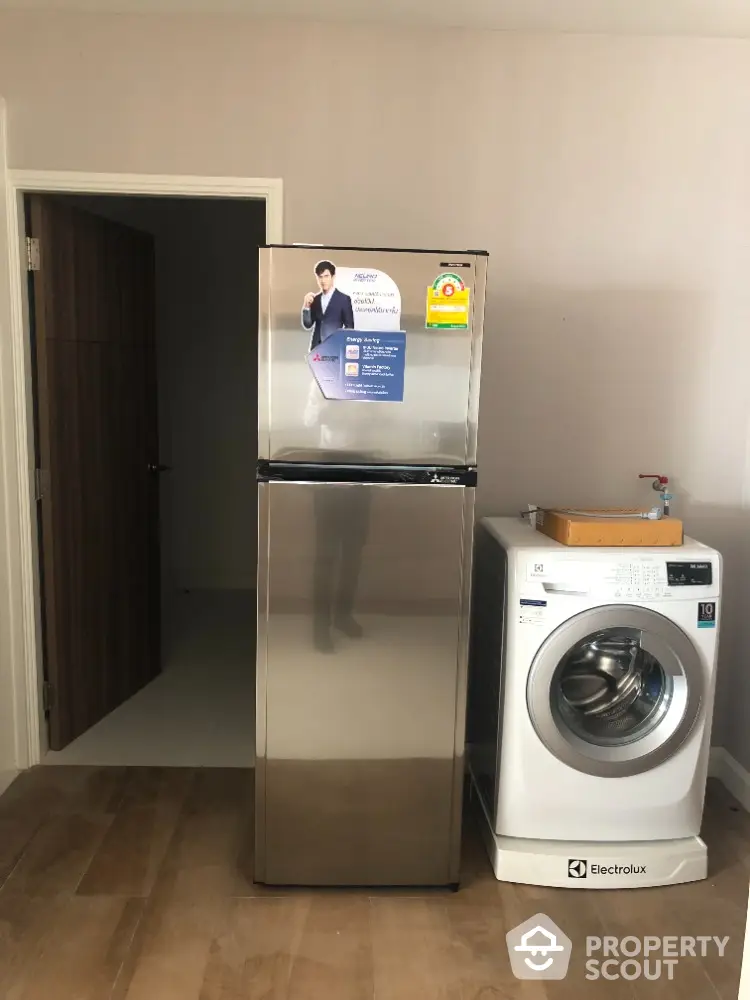 Modern laundry area with stainless steel fridge and Electrolux washing machine