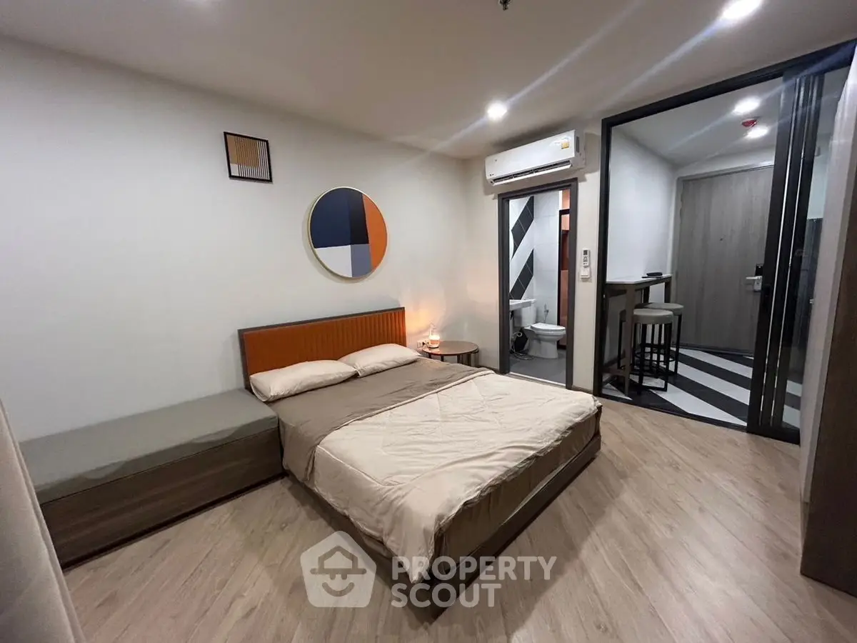 Modern bedroom with stylish decor and ensuite bathroom in a contemporary apartment.
