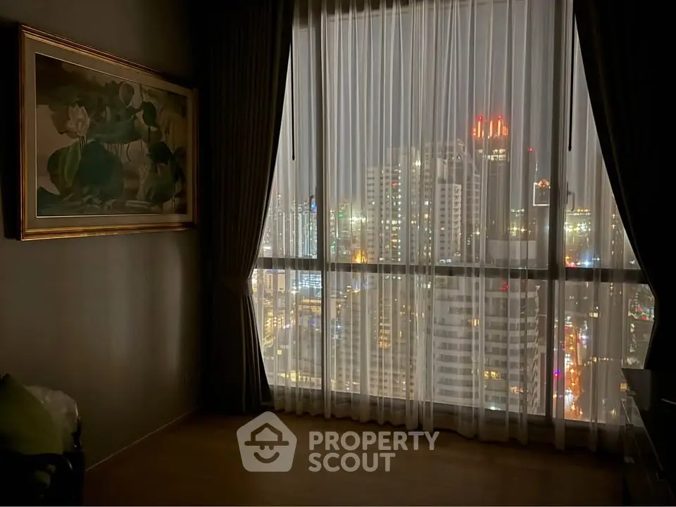 Stunning city view from a high-rise apartment with floor-to-ceiling windows and elegant curtains.