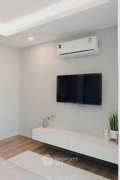 Modern living room with wall-mounted TV and air conditioning unit