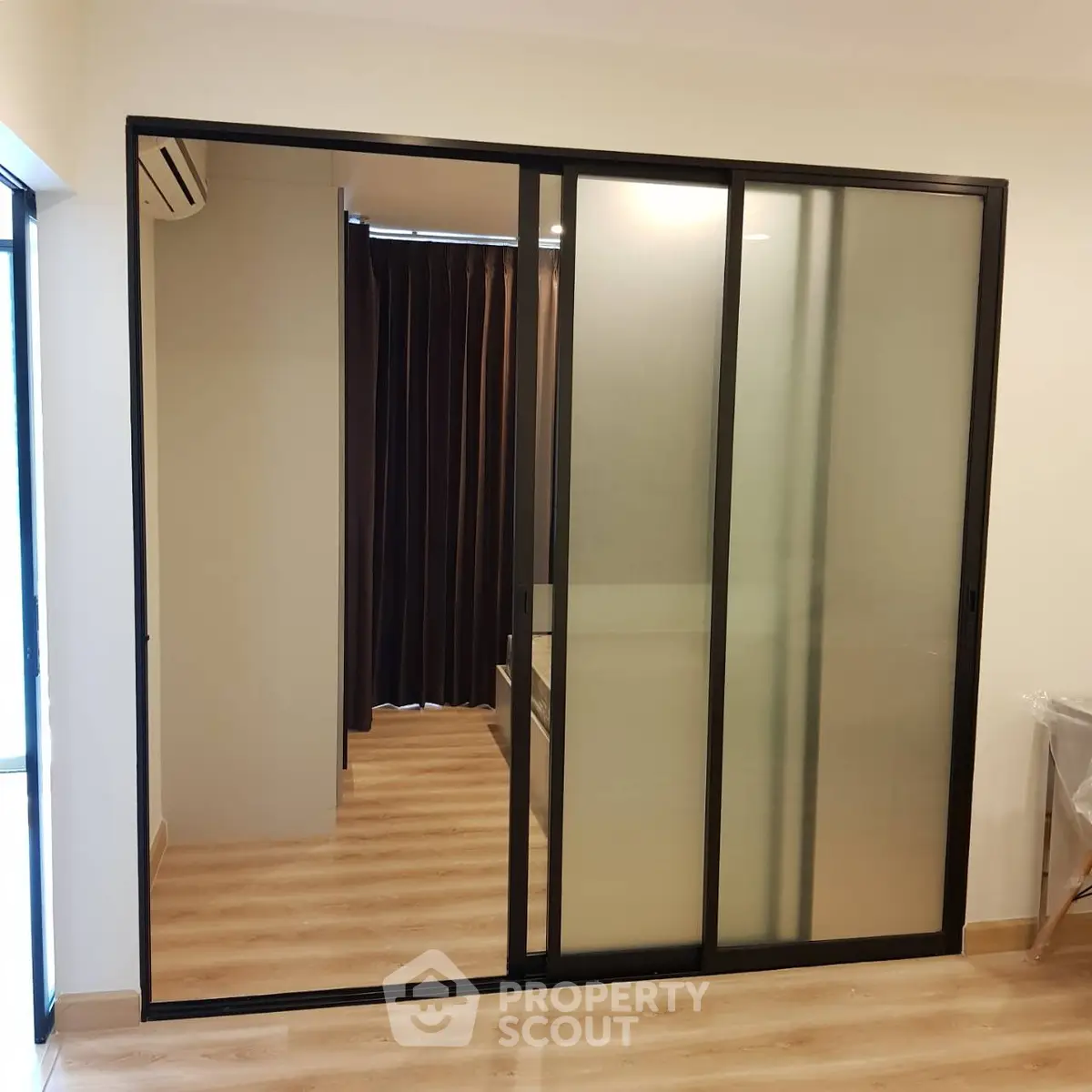 Modern interior with sliding glass doors and wooden flooring in a stylish apartment.