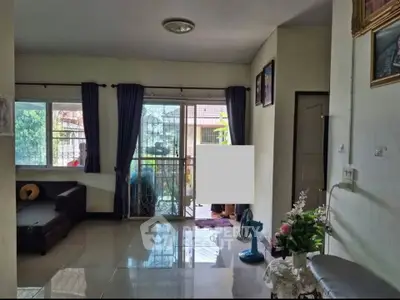 Spacious living room with large windows and garden view, perfect for family gatherings.