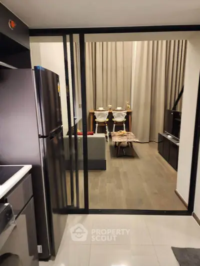 Modern open-layout kitchen leading to a stylish living area with elegant dining setup.