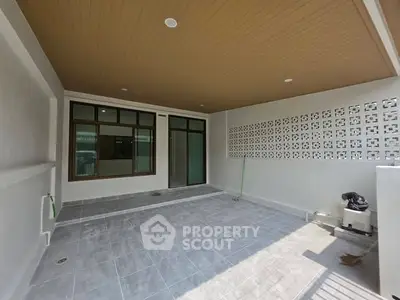 Spacious covered patio with modern design and ample natural light, perfect for outdoor relaxation.