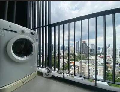 Stunning city view from high-rise balcony with washing machine, perfect for urban living.