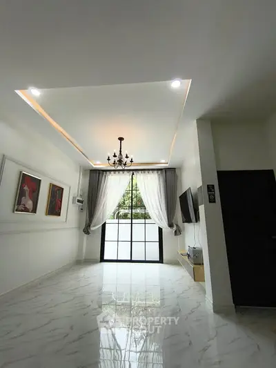 Elegant living room with chandelier, marble flooring, and large window for natural light.