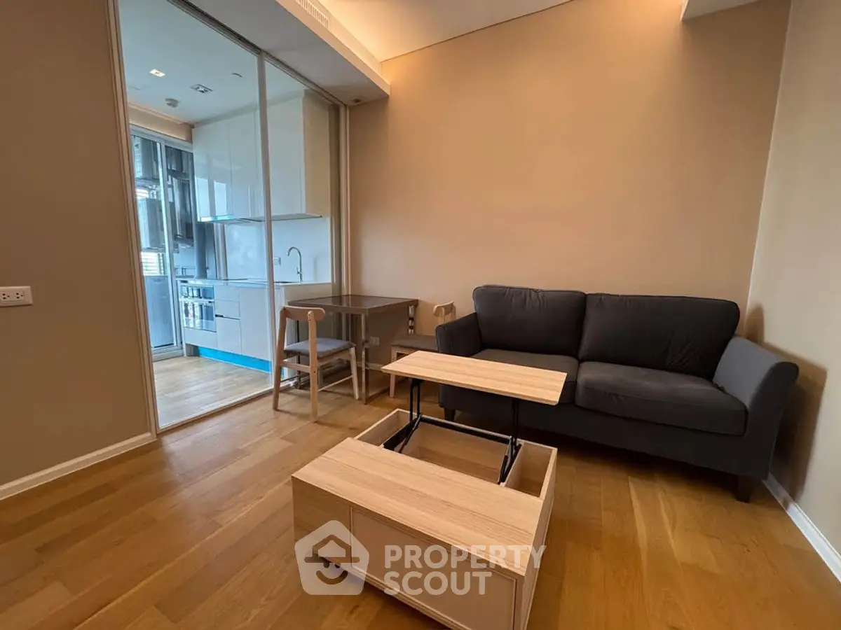 Modern living room with sleek kitchen, featuring a cozy sofa and multifunctional coffee table.