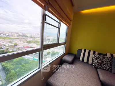 Cozy living room with panoramic city view through large window, modern sofa and vibrant wall color.