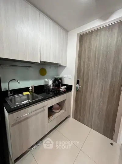Compact modern kitchen with sleek cabinetry and stainless steel sink