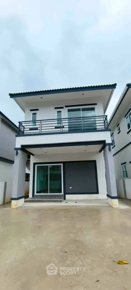 Modern two-story house with sleek balcony and spacious driveway