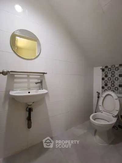 Modern bathroom with sleek white tiles and compact fixtures