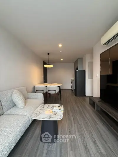 Modern living room with stylish furniture and open kitchen layout in a contemporary apartment.
