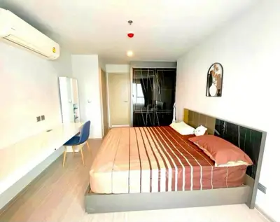 Modern bedroom with stylish decor and workspace in a bright apartment.
