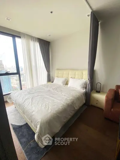 Luxurious bedroom with city view, featuring elegant decor and ample natural light.