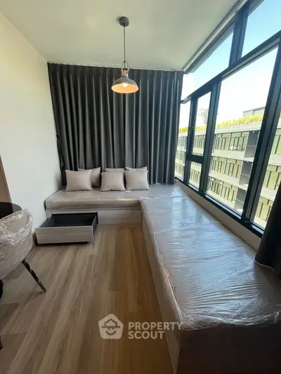 Modern living room with large windows and cozy seating area