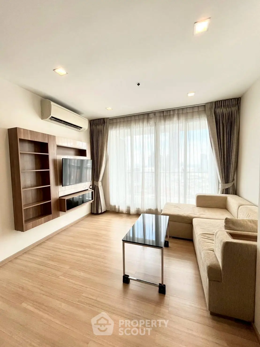 Spacious living room with modern decor and large windows offering natural light.
