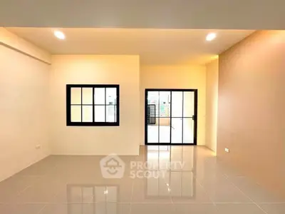 Spacious modern living room with large windows and glossy tiled floors