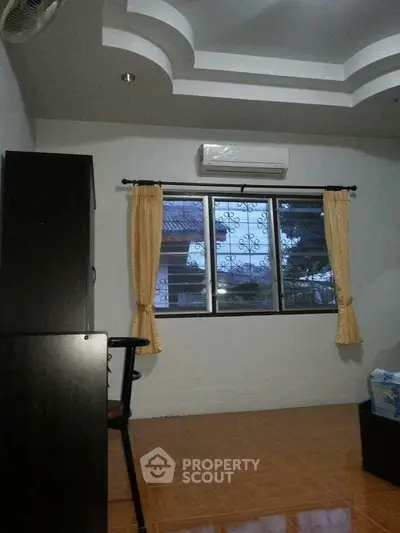 Cozy bedroom with air conditioning and window view, featuring modern ceiling design and warm lighting.