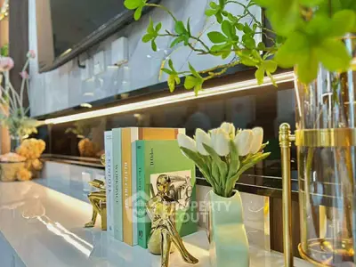 Elegant interior decor with books, plants, and golden accents on a modern shelf.