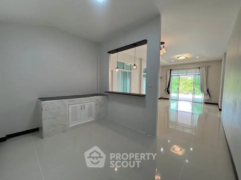 Spacious modern living room with glossy tile flooring and large windows for natural light.
