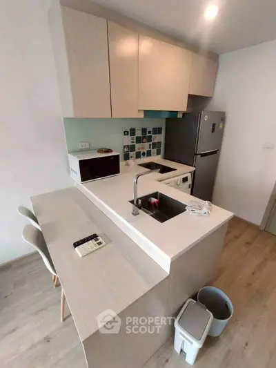 Modern kitchen with sleek cabinetry and integrated appliances in a compact layout.