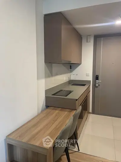Modern compact kitchen with sleek cabinetry and integrated appliances