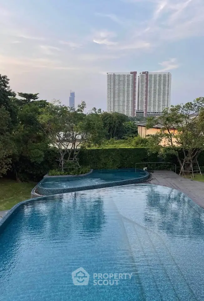 Luxurious pool with stunning cityscape view and lush greenery