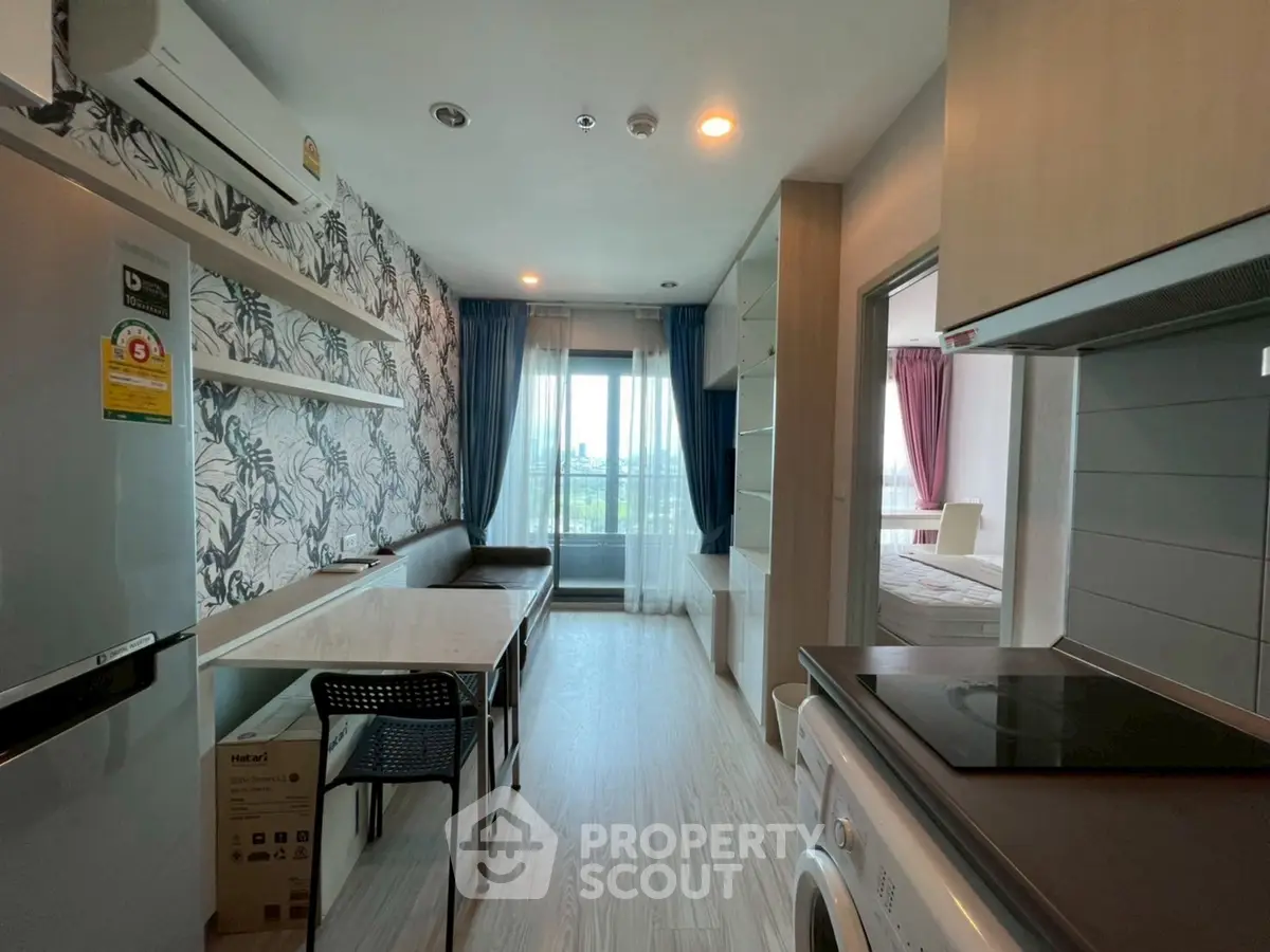 Modern apartment with open kitchen and stylish decor, featuring a washing machine and bright natural light.