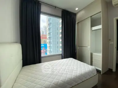 Modern bedroom with large window and built-in closet in urban apartment