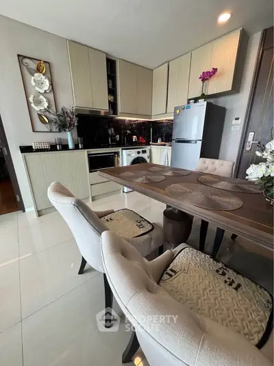 Modern kitchen with dining area featuring sleek cabinetry and elegant decor